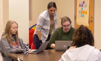 Educational technology students prepare curricula on their laptops.