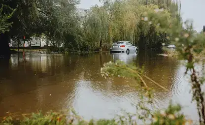 A car sits in high water as a flood recedes from a neighborhood.