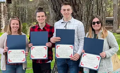 Students hold up their Earth and Atmospheric Sciences scholarship certificates.