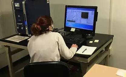 Student works at the Scanning Electron Microscope terminal.