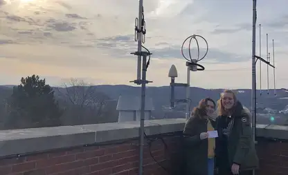 Students post with the rooftop weather station.