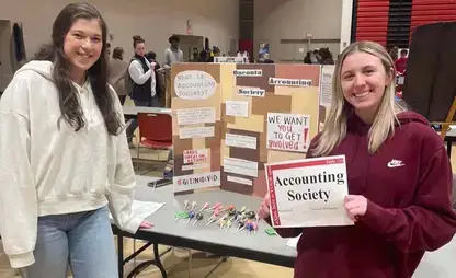 Members of the Accounting Society pose in front of their club table.