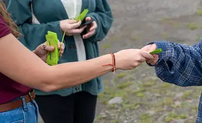 A student hands a ticket to another person.