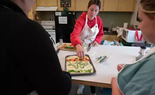 Students watch as a tray of focaccia is prepared. 
