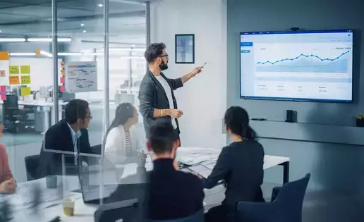 A business analyst reviews data with a group of investors