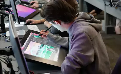 A digital computer art student uses a large tablet to create