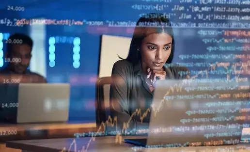 An individual reviews information on a laptop, as seen through a screen of computer code