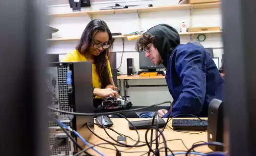 Students work on computer hardware in a computer science and robotics class