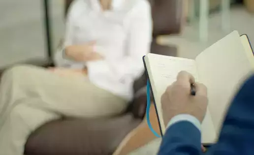 Counselor takes notes during a session