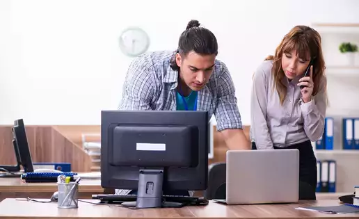 IT Desktop support representative assisting a coworker