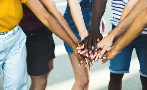 A variety of hands overlap each other in a show of solidarity