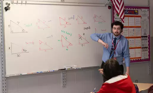 A teacher goes over mathematics principles with a class of students