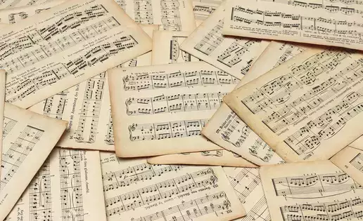 Multiple sheets of music scattered in a pile