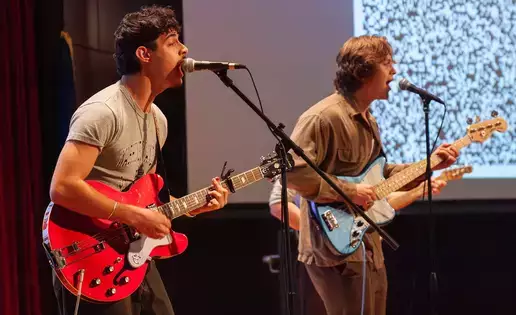 Two young men playing guitars at O Factor competition.