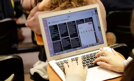 A faceless individual works on a writing assignment