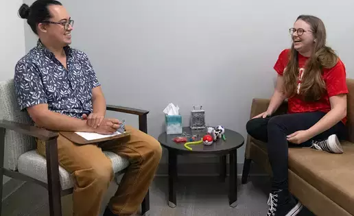 School counselor meets with smiling student in their office. 