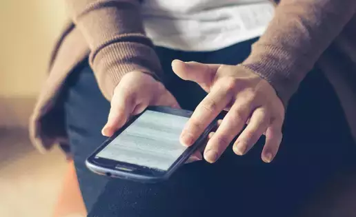 An unknown individual is scrolling social media on their phone