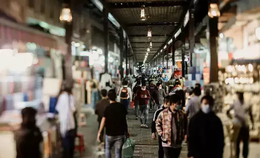 A busy street scene with hundreds of individuals walking and shopping