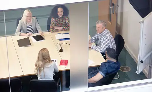 High angle view of businessmen and women having meeting at conference table