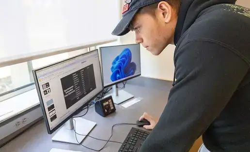 Student with physics software on two monitors.