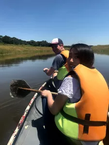 Students rowing a canoe down a river in Zimbabwe.