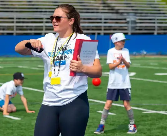 Sports Management student directs young students at a soccer training camp.