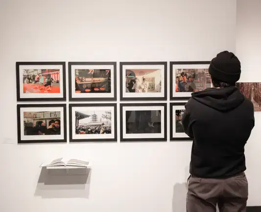 A patron examines photos on a gallery wall.