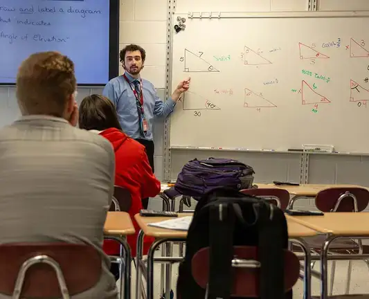 Secondary Education student teaching math in front of a whiteboard.