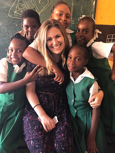 Student smiling with Jamaican elementary students